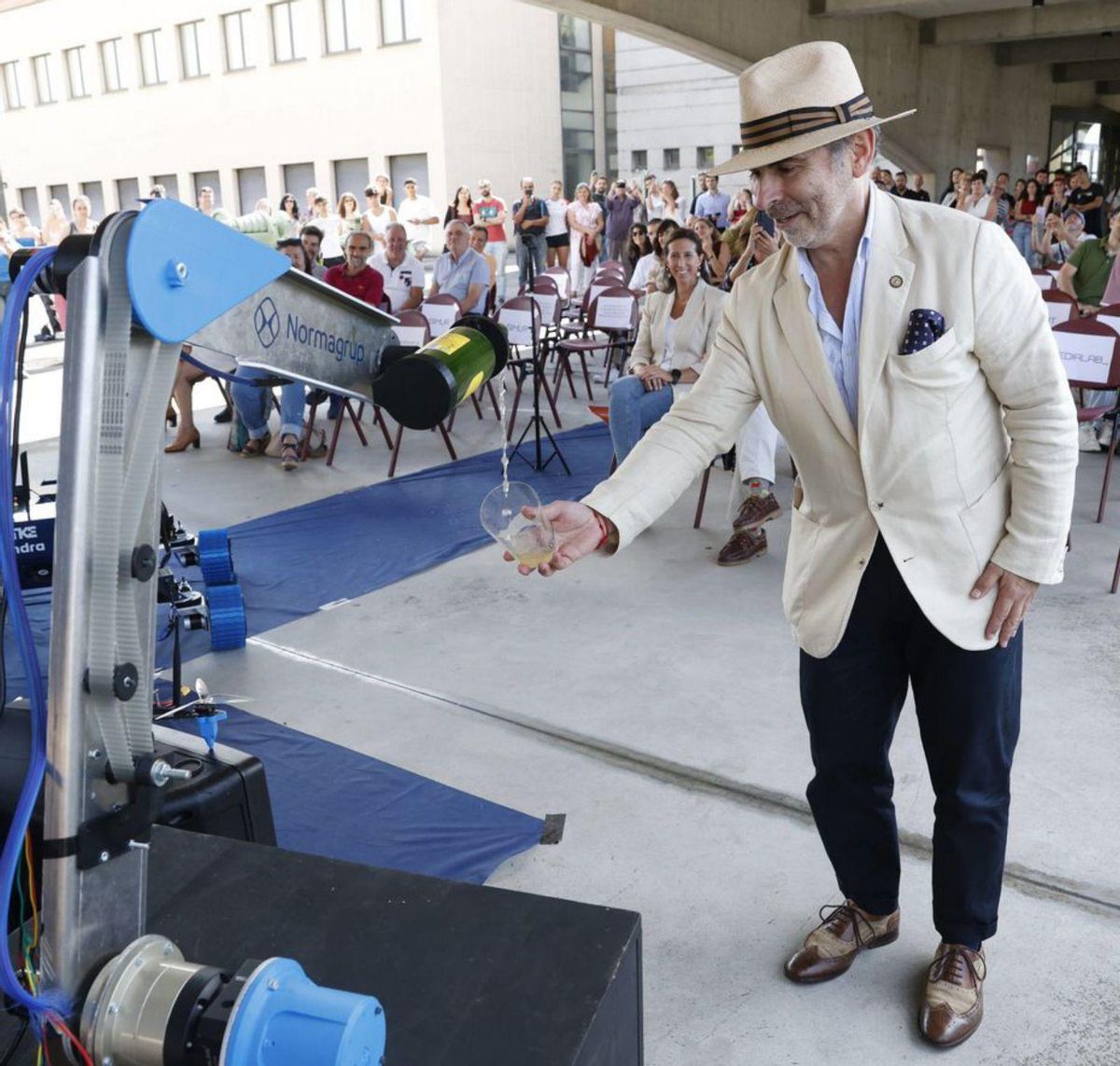 El brazo del robot, escanciando un culín a Ignacio Villaverde.
