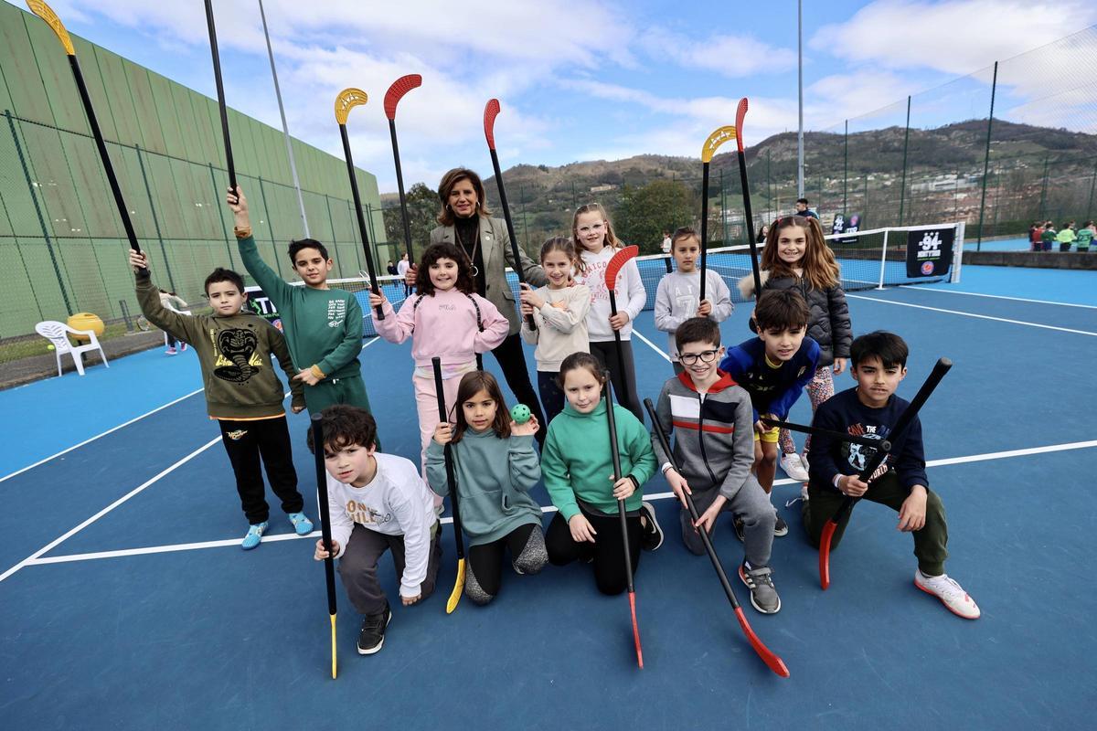 La edil Concepción Méndez junto a los niños que jugaban al hockey.