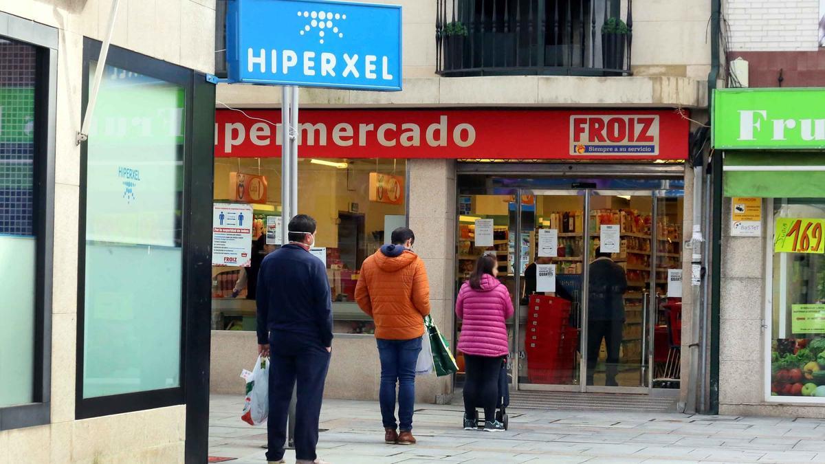 Colas de clientes para respetar la distancia de seguridad a la entrada de un supermercado de Tui. / FdV