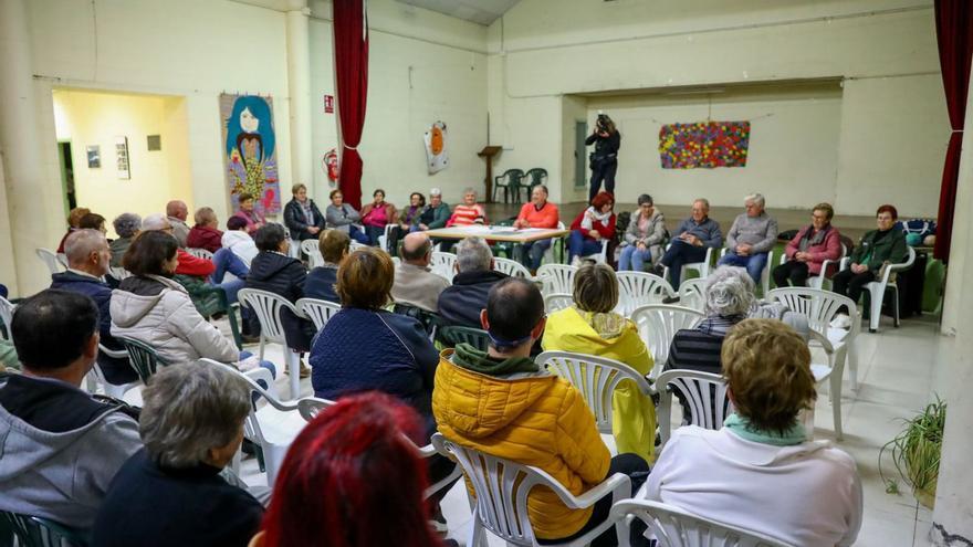 Pepe Sabarís, con jersey rojo en el centro de la mesa, durante la asamblea de O Castro. |   // IÑAKI ABELLA