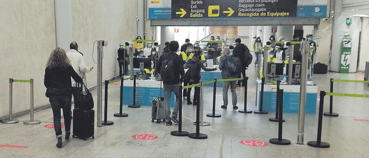 Pasajeros de vuelos internacionales a su paso por el control sanitario en el aeropuerto.