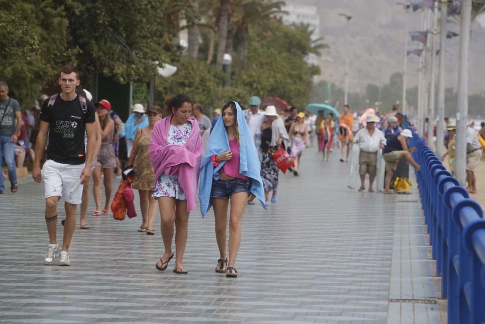 La lluvia sorprende a los bañistas en el Postiguet