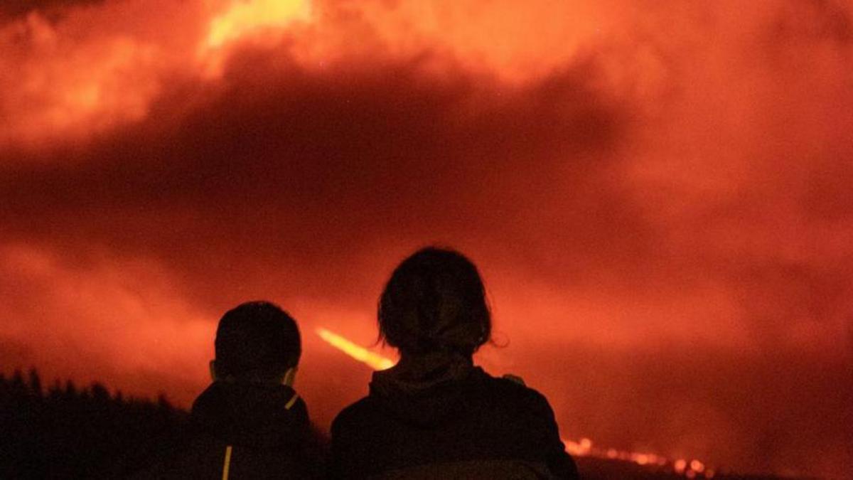 Dos niños contemplan el volcán de La Palma, en erupción.