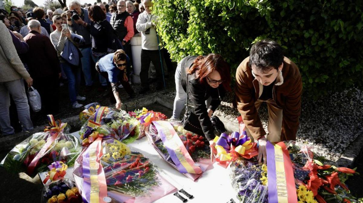 Varias personas colocan ramos sobre la fosa común de los fusilados. | JUAN PLAZA