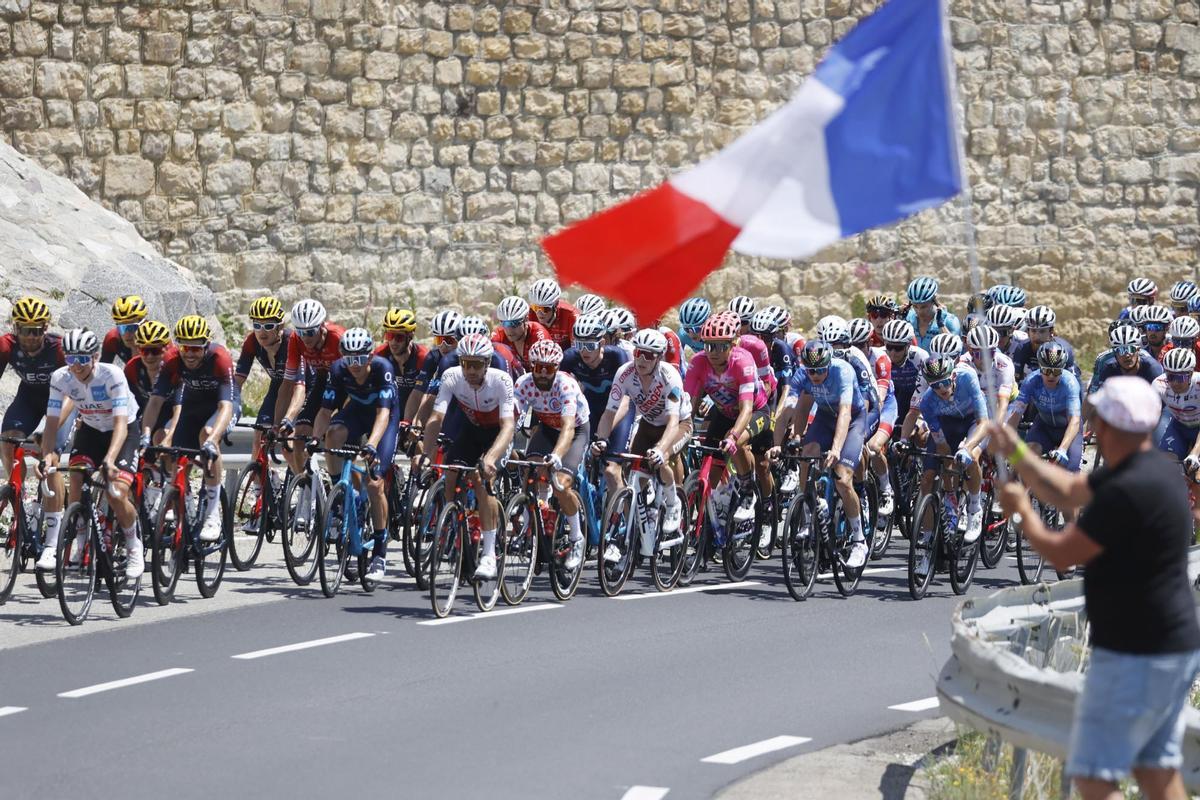 Briancon (France), 14/07/2022.- A spectator waves a French flag as riders pass next to him during the 12th stage of the Tour de France 2022 over 165.1km from Briancon to Alpe d’Huez, France, 14 July 2022. (Ciclismo, Francia) EFE/EPA/GUILLAUME HORCAJUELO