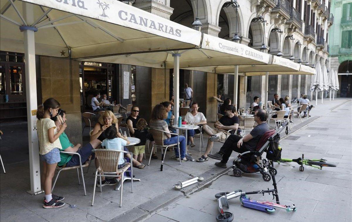 Una familia en una terraza de la plaza Reial.