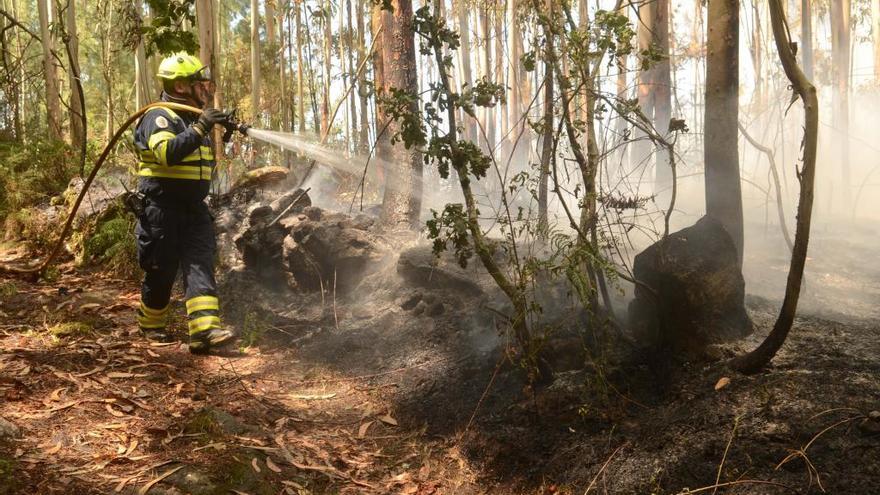 El integrante de una brigada trata de apagar las llamas en el incendio de San Miguel de Deiro