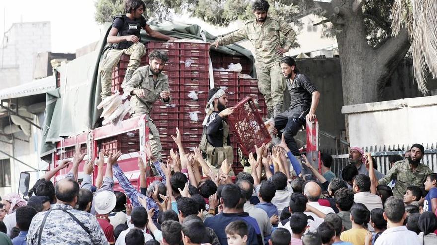 Tropas turcas reparten pan en la localidad kurda de Tal Abiad. // Reuters