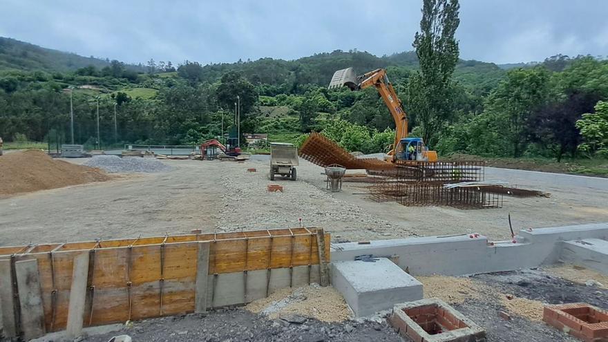 Una pala coloca los forjados en los terrenos que albergarán las pista de tierra batida. | D. M.