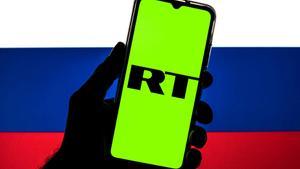 Logo de RT sobre una bandera rusa