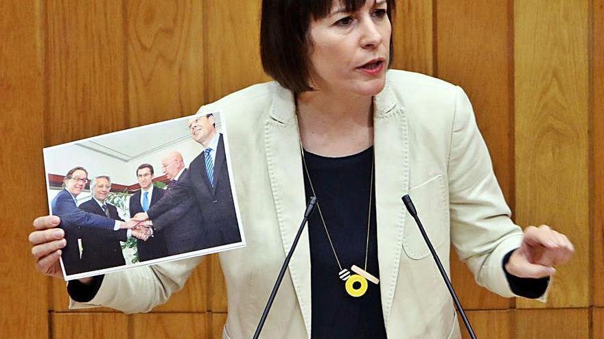 Ana Pontón muestra una fotografía de Feijóo con los responsables de las cajas, ayer durante el debate en el Parlamento.