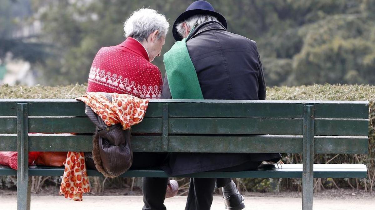 Una pareja de jubilados, en el banco de un parque.