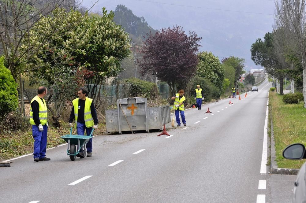 Trabajadores municipales en labores de desbroce en el paseo fluvial de Mieres con paso alternativo de vehículos