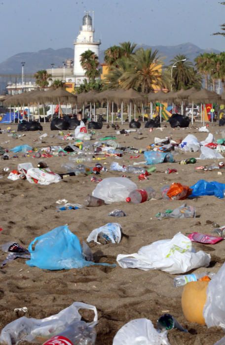 Los operarios de los servicios de limpieza trabajan para dejar la playa en óptimas condiciones tras una larga noche de fiesta en la arena