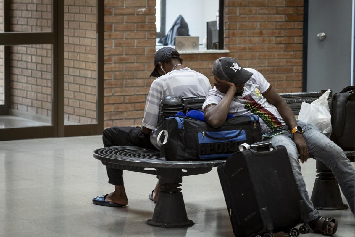 Un grupo de migrantes espera un autobús en la estación de Fraga, en una imagen de archivo.