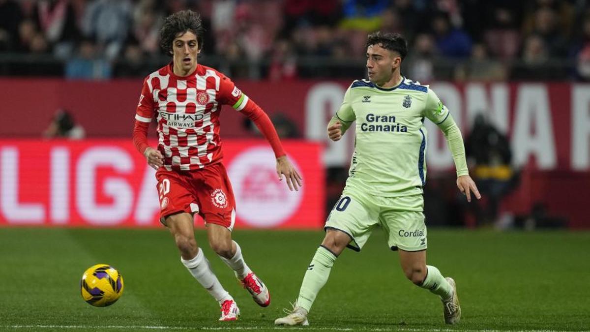 El delantero del Girona, Bryan Gil, disputa el balón ante el centrocampista de la UD Las Palmas, Alberto Moleiro