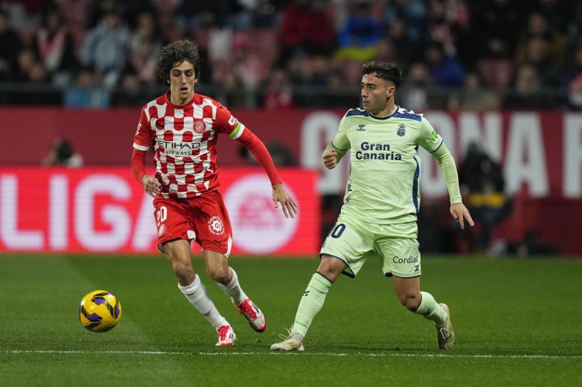 El delantero del Girona, Bryan Gil, disputa el balón ante el centrocampista de la UD Las Palmas, Alberto Moleiro