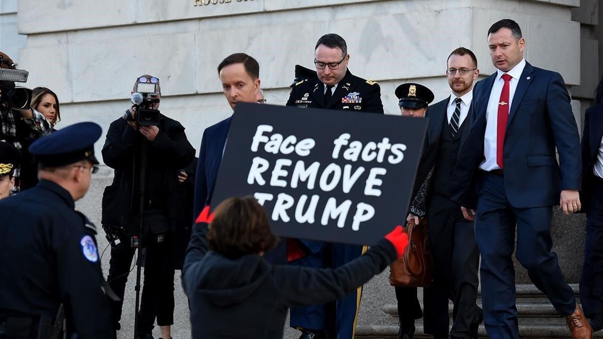 Una mujer protesta contra Trump a la salida del Congreso del asesor de seguridad nacional Alexander Vindman, el pasado 19 de noviembre.