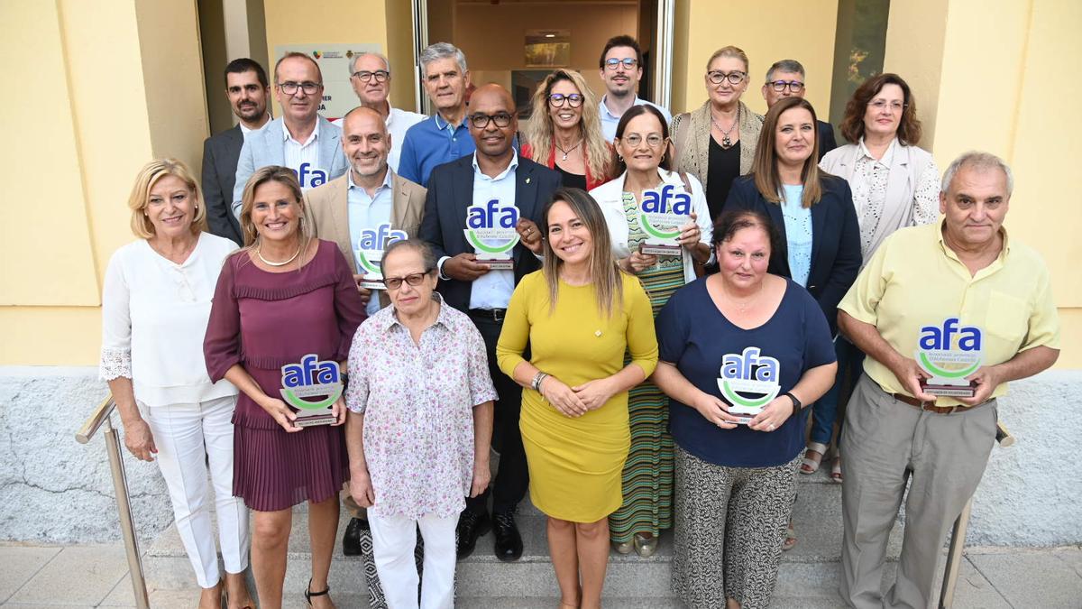 Fotografía de familia con los premiados y los representantes de la asociación y del Ayuntamiento de Castelló.