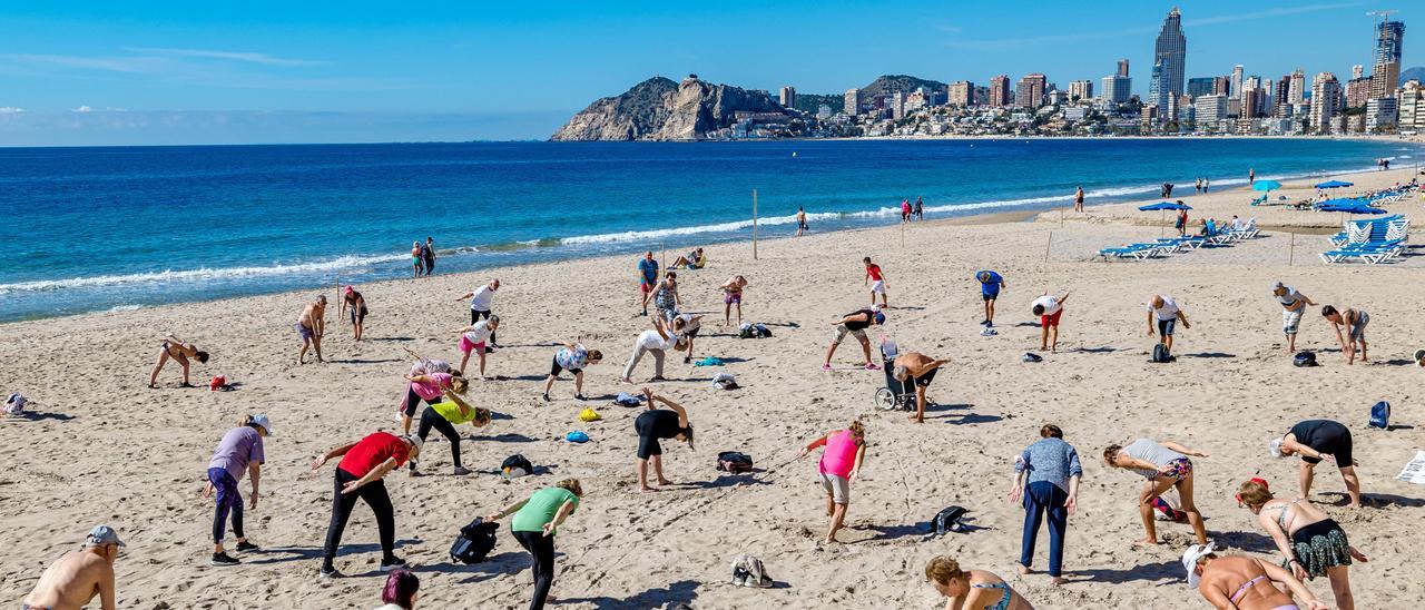 Jubilados del Imserso haciendo gimnasia en la playa de Poniente de Benidorm esta primavera