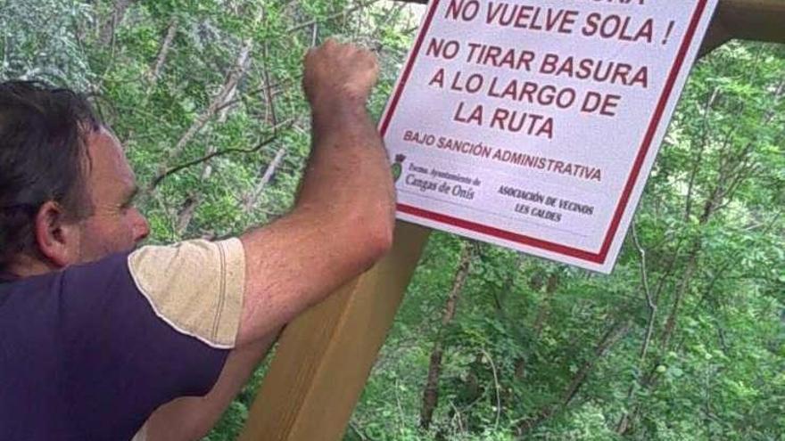 Javier Esteban Villaverde cuelga un cartel a la entrada de la ruta de la Olla de San Vicente.