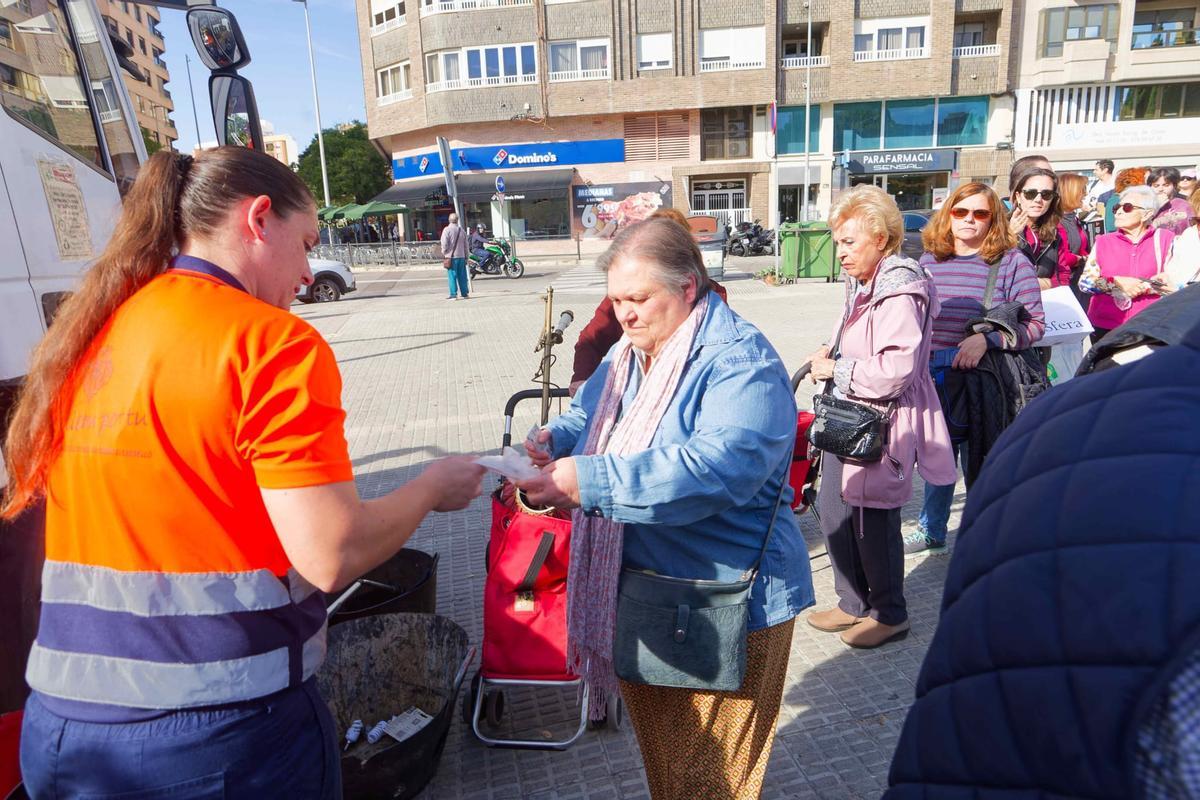 Una señora deposita un enser para reciclar.