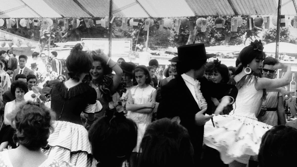 Feria de 1963 | Bailando sevillanas. Fíjense en los peinados, el traje de gitana-minifalda y las banderitas: de EEUU y el Japón imperial.