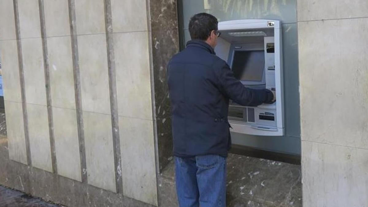 Un hombre realiza gestiones en un cajero automático, en una imagen de archivo.