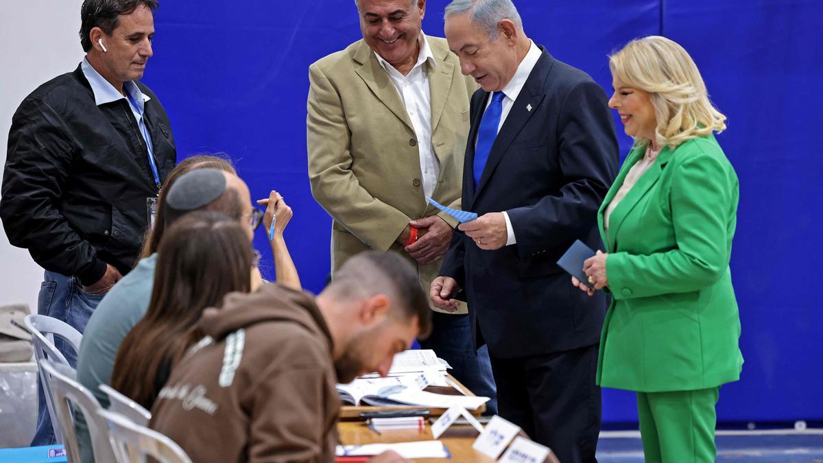 Benjamin Netanyahu (C) y su esposa Sara (R) llegan a un colegio electoral en Jerusalén en la quinta elección del país en menos de cuatro años.