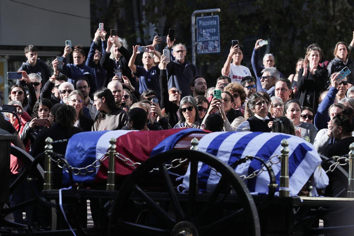 AME7436. MONTEVIDEO (URUGUAY), 14/05/2025.- Personas asisten al cortejo fúnebre del expresidente uruguayo José Mujica este miércoles, en Montevideo (Uruguay). El cortejo fúnebre del expresidente Mujica partió desde el Palacio Estevez de Montevideo, donde el actual mandatario, Yamandú Orsi, colocó el pabellón patrio sobre el féretro. EFE/ Alejandro Prieto