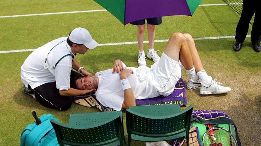 Isner recibe atención médica durante su partido de ayer.