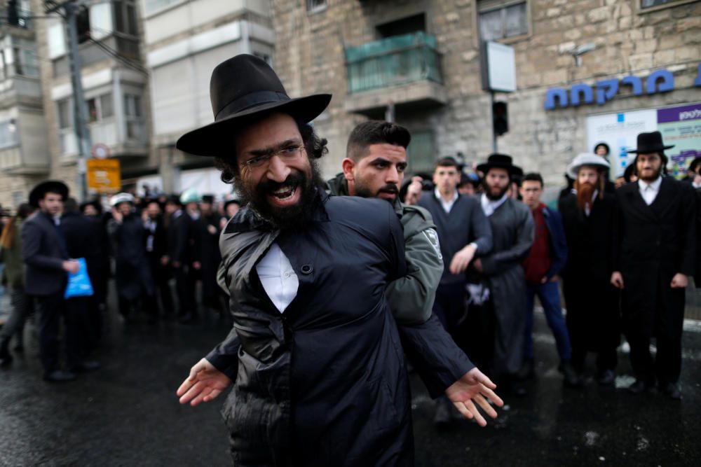 Un manifestante ultraortodoxo es detenido por un policía fronterizo durante unas protestas en contra de los miembros de la comunidad ultraortodoxa que sirven el ejército israelí que se han dado en Jerusalén.