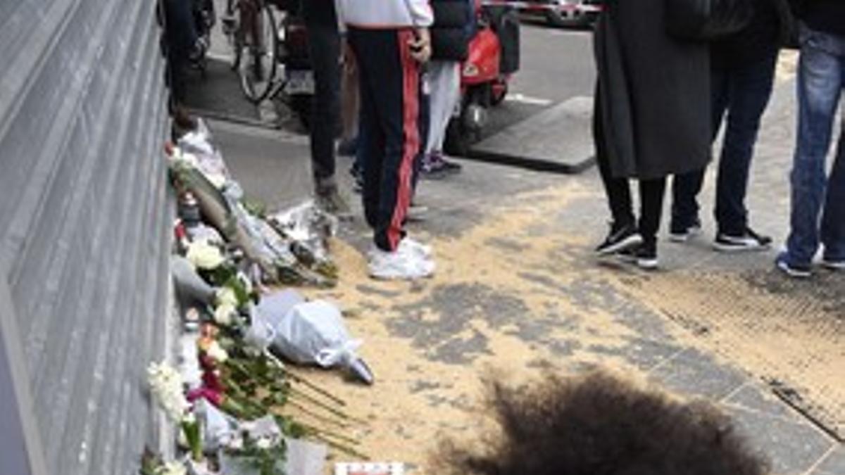 Una mujer deposita un ramo de flores frente al resturante camboyano de la Rue Albert en París.