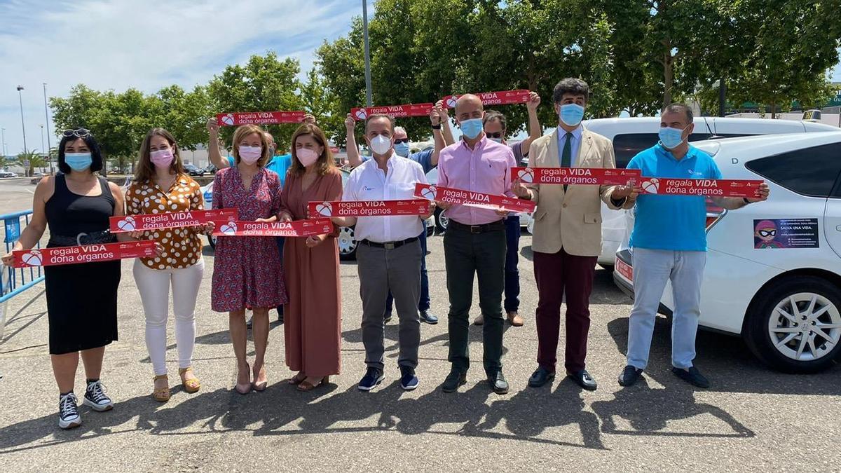 Representantes de los taxistas, del hospital y de Salud, en la campaña de pegada de carteles por la donación de órganos.