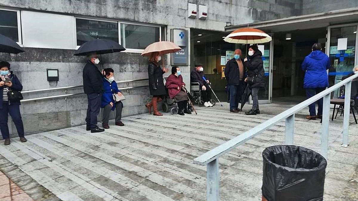 Bajo la lluvia esperando por la vacuna en Moreda