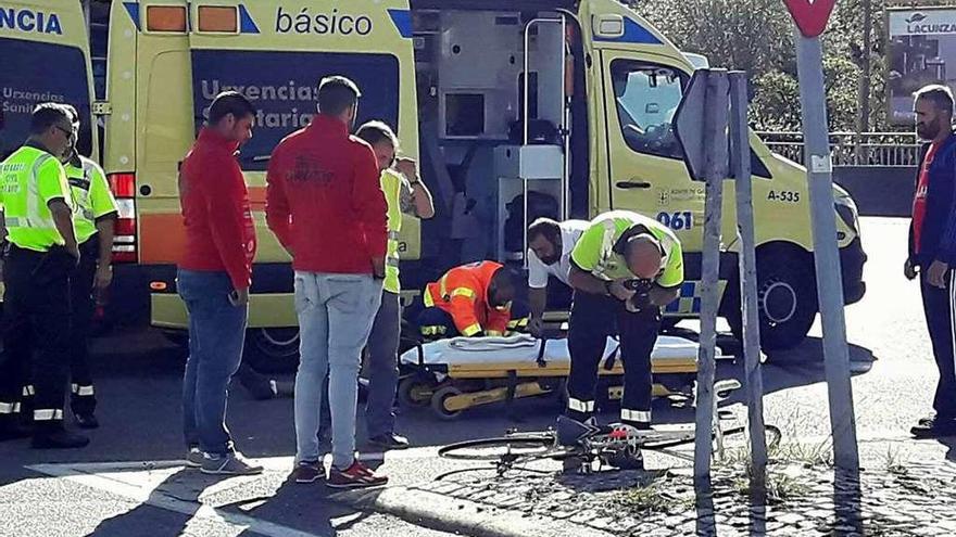 Un guardia civil fotografía la bicicleta mientras una ambulancia atiende al herido en Poio. // G. Santos