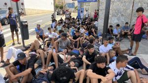 FOTODELDIA CEUTA, 10/08/2026.-Multitud de menores migrantes esperan para su filiación frente a la Jefatura Superior de la Policía Nacional en Ceuta este lunes. La situación en Ceuta sigue lejos de normalizarse, con campamentos provisionales para muchos migrantes y miles de menores a la espera de una solución, y continúa marcando la disputa entre el Gobierno y el PP, que mantiene el pulso para que tres ministros comparezcan en el Senado aunque desde el Ejecutivo solo piensen hacerlo en el Congreso. -EFE/ Reduan