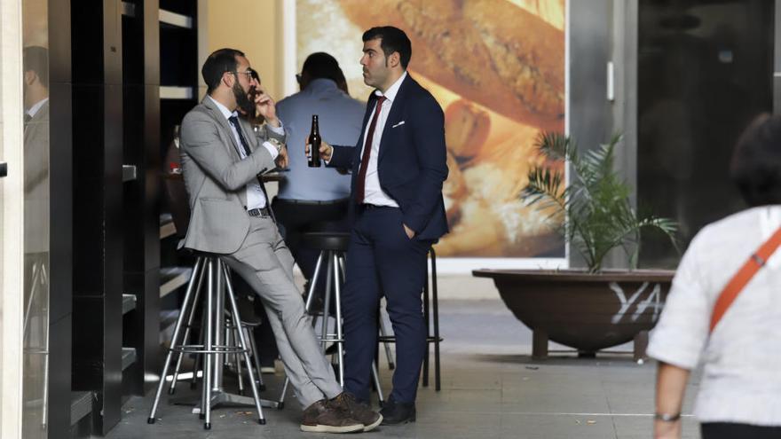 Dos personas en la zona exterior de un bar de la Plaza de las Flores.