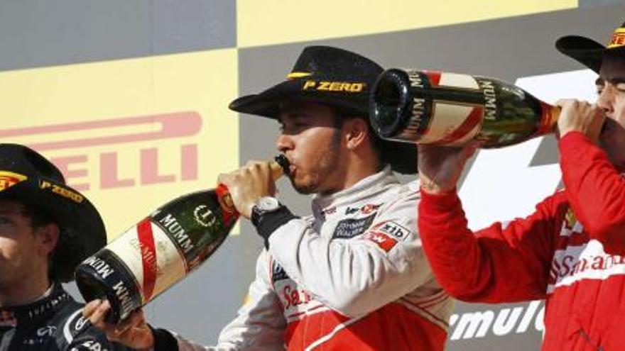 Sebastian Vettel, Lewis Hamilton y Fernando Alonso beben champán en el podio, con sombreros texanos de un patrocinador. // Robert Galbraith