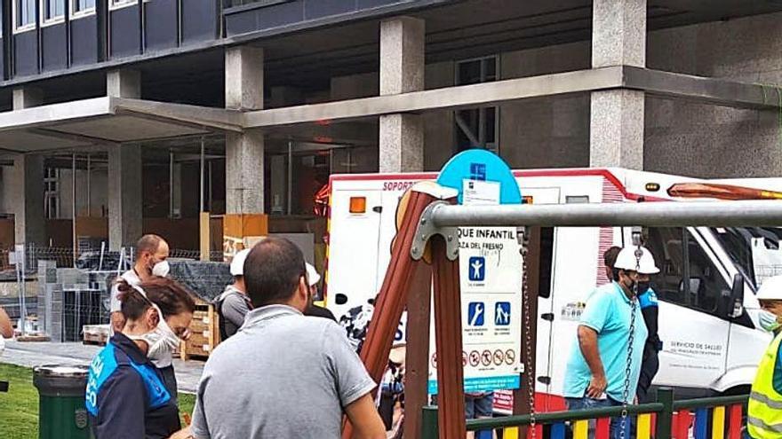 El padre del niño (de espaldas) habla con una policía, con la barra de hierro en el suelo y la ambulancia al fondo.