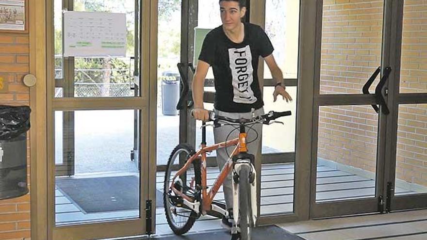 Un alumno acude al instituto en su bicicleta.