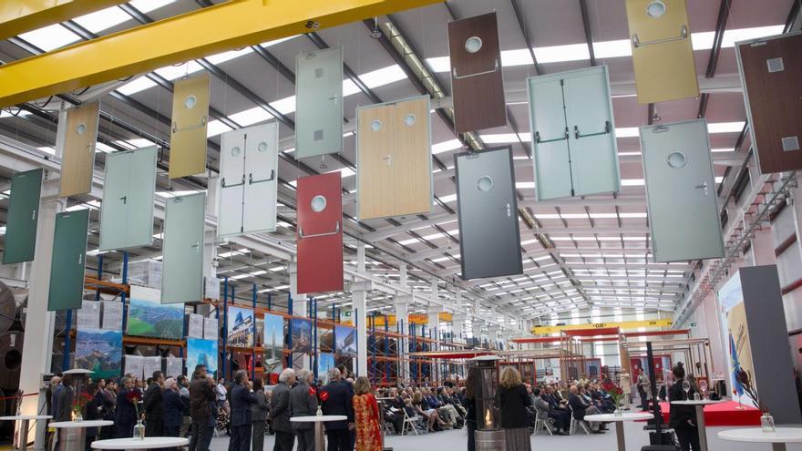 La nave de ampliación de Asturmadi, ayer, durante la inauguración; del techo cuelgan modelos de puertas que fabrica la empresa avilesina. | MIKI LÓPEZ