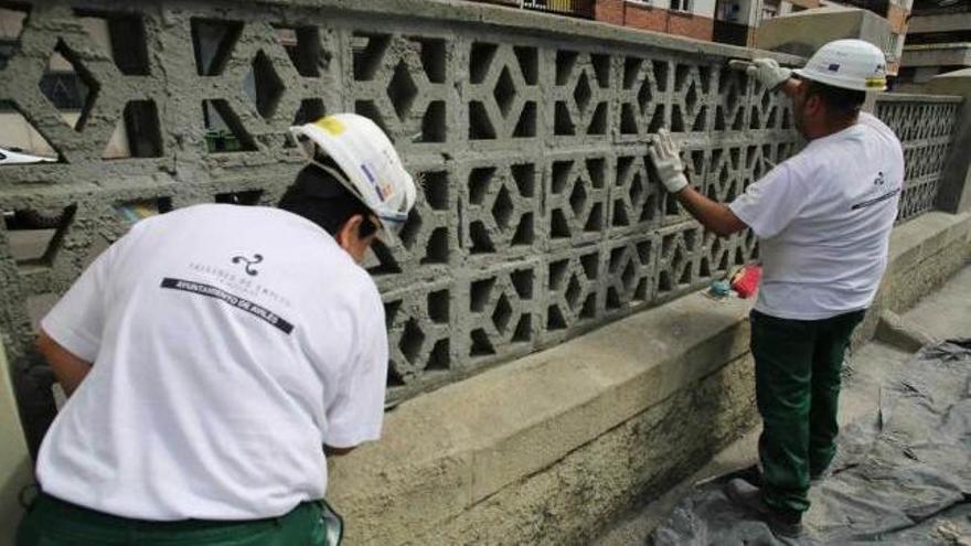 Dos trabajadores, en una de las actividades de un taller de empleo de Avilés.