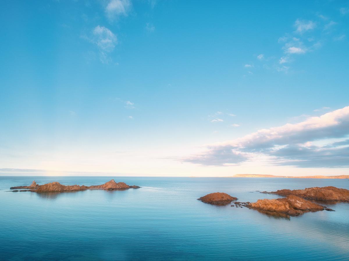 Atardecer dorado sobre la playa de Pregonda, isla de Menorca