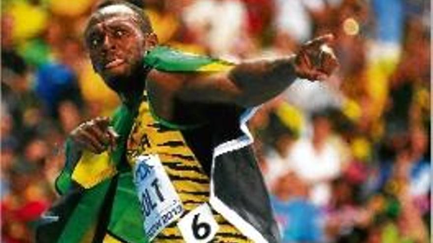 Bolt celebra la victòria amb una bandera jamaicana.