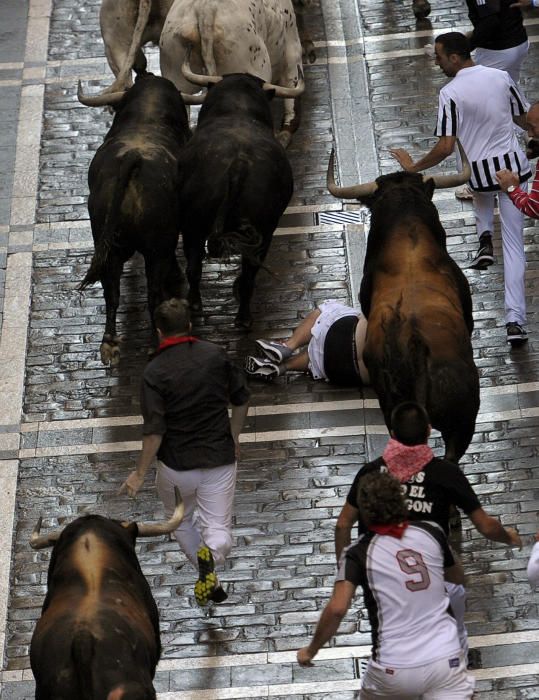 Una manada de toros de la ganadería de Fuente Ymbro, que se ha ido estirando en el recorrido hasta romperse en la calle Estafeta, ha creado emoción en el primer encierro de los Sanfermines de 2016.