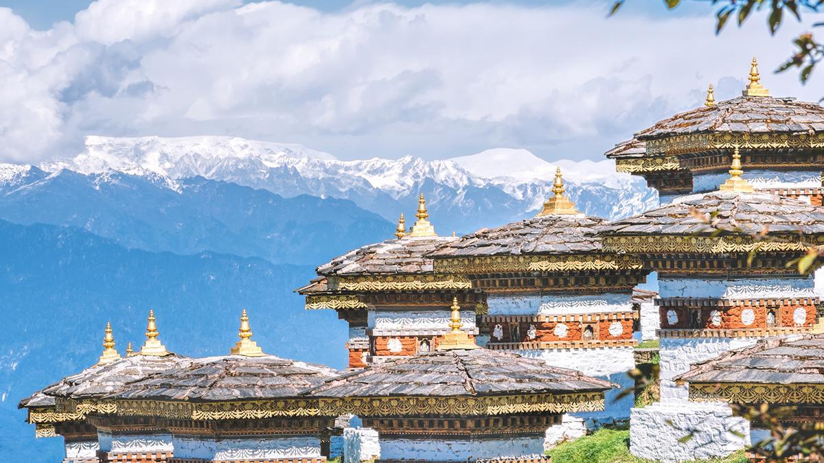Los tejados tradicionales de Bután, con las montañas del Himalaya al fondo, resumen la fuerza paisajística del país.