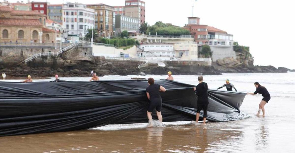 Algunos de los participantes, ayer, en la "performance" que se hizo en la playa de San Lorenzo.