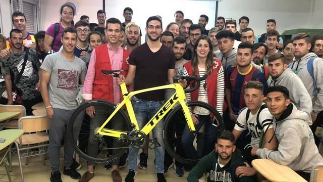 Andrés Contreras sostiene su bicicleta, rodeado de responsables de la Cruz Roja y de alumnos.