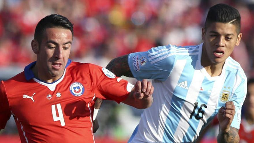 El defensa argentino Marcos Rojo (d) pelea un balón con el defensa chileno Mauricio Isla.